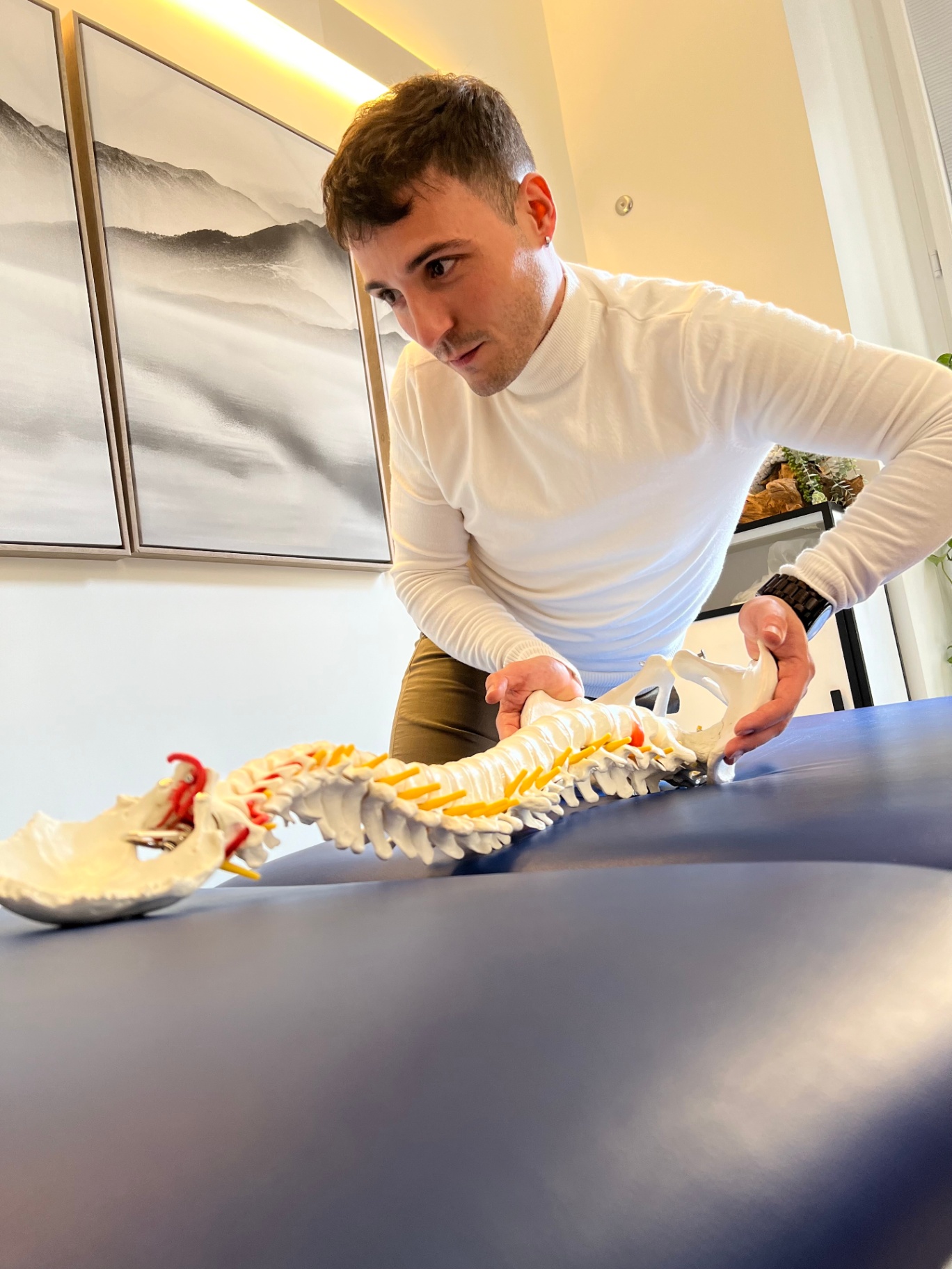 Simone Loi osteopata nello studio con modello anatomico